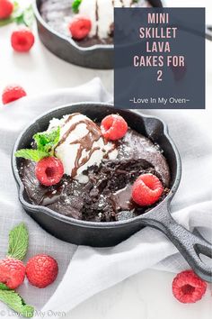 a skillet with chocolate cake and raspberries in it on a white table