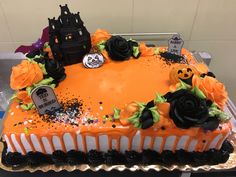 a decorated halloween cake with black and orange frosting, roses and sprinkles