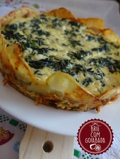 a quiche with cheese and spinach on a white plate