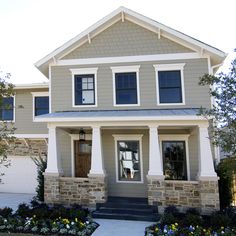 a house that is in the middle of some grass and flowers on the front lawn