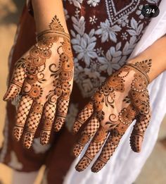 the hands are decorated with henna designs on it's palms and fingers,