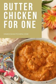 a bowl of butter chicken for one on a plate with rice and flowers in the background