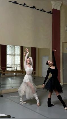 two ballerinas are in the middle of a dance class with their arms outstretched