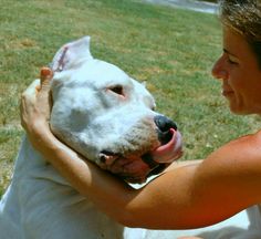 a woman holding a white dog in her arms