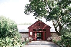 a red barn is surrounded by greenery and trees