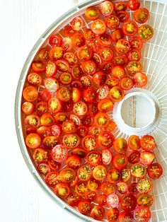 tomatoes in a food processor on a white surface with the top half cut off and ready to be cooked