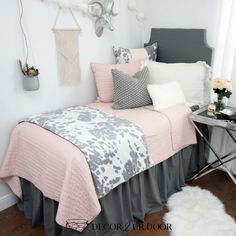 a bed with pink and gray comforters in a bedroom