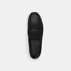 a pair of black loafers sitting on top of a white surface