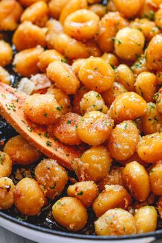 a wooden spoon is being used to stir up some chickpeas in a skillet