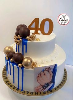 a white cake with blue and gold icing on it's top has the number forty