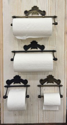 three toilet paper rolls are hanging on the wall next to two black iron towel racks