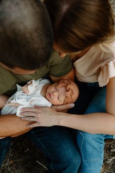 a man and woman holding a baby in their arms