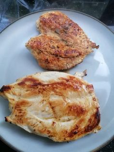 two pieces of meat sitting on top of a white plate