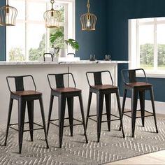 three stools are sitting in front of a kitchen island with marble countertops and blue walls