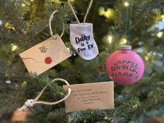 three christmas ornaments hanging from a tree with tags attached to the top and bottom of each ornament