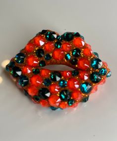 an orange and blue beaded bracelet on a white surface