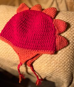 a red knitted hat sitting on top of a pillow