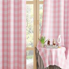 a pink and white checkered curtain in front of a window