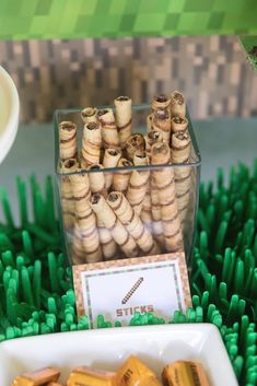 there are many small pieces of food in the trays on the table with green grass