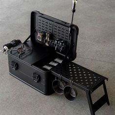 an open suitcase sitting on top of a table with tools in it and some other items inside