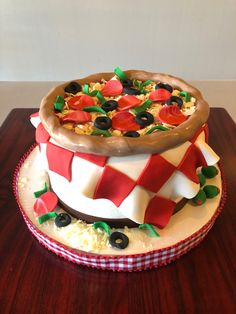 a large pizza cake sitting on top of a wooden table