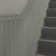 an empty staircase leading up to the top floor in a house with white walls and gray carpet