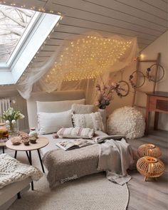 an attic bedroom with white furniture and lights on the ceiling, along with a large window