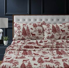 red and white bedding with deer, trees, and snow on it in a bedroom