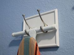 a pair of scissors hanging from a hook on a blue wall next to a towel