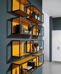 the shelves are filled with books, plants and other things in yellow glass cases on them