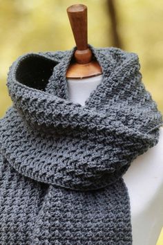 a gray knitted scarf sitting on top of a mannequin