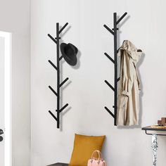 a coat rack with hats and purses hanging on the wall next to a bench