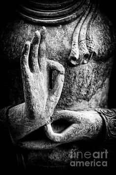 a black and white photo of a buddha statue with his hands folded in front of him