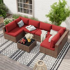 an outdoor living room with red couches and pillows