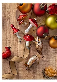 an overhead view of christmas decorations on a wooden table with mushrooms and other holiday items