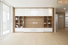 an empty room with wooden floors and white cabinets on the wall, along with large sliding glass doors