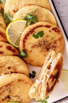 some food that is on a plate with lemons and cilantro wedges