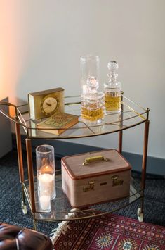 a glass table with two bottles on it and a suitcase sitting next to the table