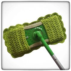 a green crocheted cell phone case with a plastic pickle in it's holder