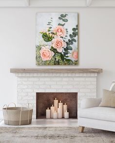 a living room with a white couch, fireplace and painting on the wall above it