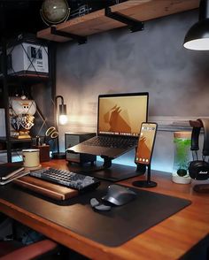 a laptop computer sitting on top of a wooden desk next to a mouse and keyboard