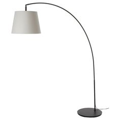 a black floor lamp with a white shade on the top and an oval shaped base