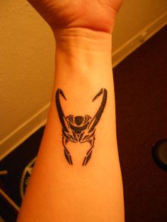 a tattoo on the wrist of a person with an animal head in it's center