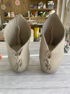 two vases sitting on top of a wooden table