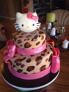 a hello kitty cake with pink bows and leopard print