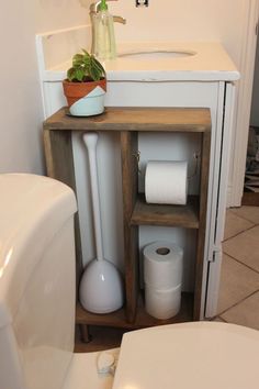 a bathroom with a sink, toilet paper and a shelf next to the bathtub