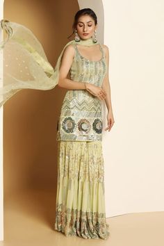 Light green sleeveless padded short kurta in georgette base with metallic sequin vines, chevron and floral swirl embroideries. Paired with a sequin garden embellished tiered sharara and ditsy sequin motif embellished net dupatta. - Aza Fashions Green Sharara With Zari Work For Summer, Sleeveless Georgette Sharara With Mirror Work, Semi-stitched Sleeveless Palazzo Set With Mirror Work, Green Sleeveless Dress For Diwali, Fitted Sleeveless Sharara For Summer, Sleeveless Sharara With Dupatta, Green Sleeveless Georgette Dress, Green Sleeveless Lehenga For Summer, Sleeveless Green Georgette Dress