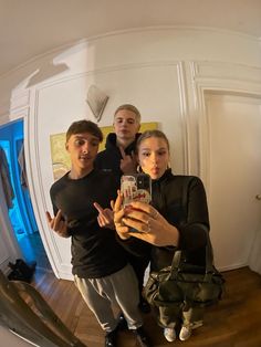 three people taking a selfie in front of a mirror with the reflection of them