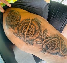 a woman with a tattoo on her thigh and roses in the middle of her leg