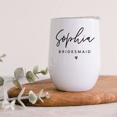 a bridesmaid wine glass sitting on top of a wooden board